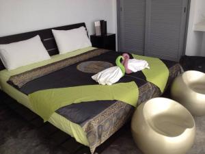 a bedroom with a bed with two swans on it at La maison du bonheur à samui in Koh Samui