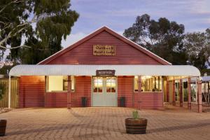 un edificio rojo con un cartel en la parte delantera en Outback Hotel, en Ayers Rock