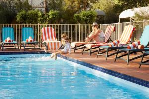 una mujer y un niño jugando en una piscina en Outback Hotel, en Ayers Rock