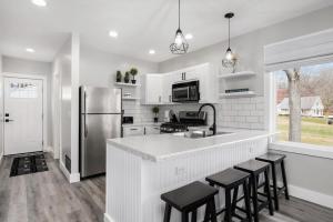 uma cozinha com um frigorífico de aço inoxidável e bancos em Lakeside House by Michigan Waterfront Luxury Properties em Montague