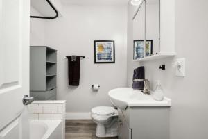 uma casa de banho branca com um WC e um lavatório em Lakeside House by Michigan Waterfront Luxury Properties em Montague