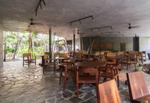 a dining room with wooden tables and chairs at Spectacular Villa Gaia/PH/private pool in Tulum
