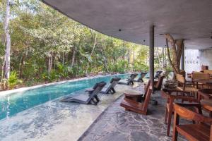a swimming pool with tables and chairs next to a resort at Spectacular Villa Gaia/PH/private pool in Tulum