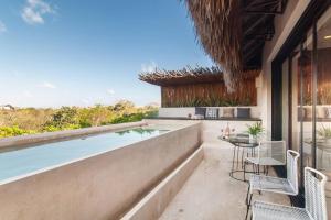 an outdoor patio with a pool and chairs and a table at Spectacular Villa Gaia/PH/private pool in Tulum