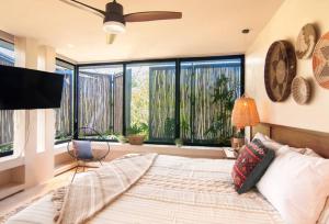 a bedroom with a large bed and a large window at Spectacular Villa Gaia/PH/private pool in Tulum