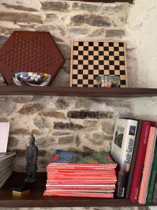 un estante lleno de libros y un tablero de ajedrez en Le Balcon Commingeois en Chein-Dessus