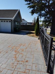 a driveway with a fence in front of a house at Nini Sweet home in Richmond +8 photos