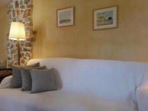 a bedroom with a white bed with two pictures on the wall at Villa Agali. in Agia Anna