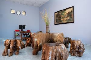 a living room with two wooden cows and two stools at Nhà Nghỉ Vườn Oải Hương LAVENDER GARDEN GUEST HOUSE in Phu Quoc