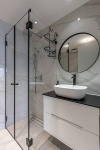 ein weißes Badezimmer mit einem Waschbecken und einem Spiegel in der Unterkunft BnBennaim - Bella apartment in Tel Aviv