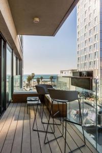 einen Balkon mit 2 Stühlen und einem Tisch auf einem Gebäude in der Unterkunft BnBennaim - Bella apartment in Tel Aviv