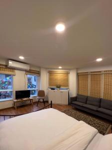 a bedroom with a bed and a couch and a tv at Ananya Apartments Phase 2 in Kathmandu