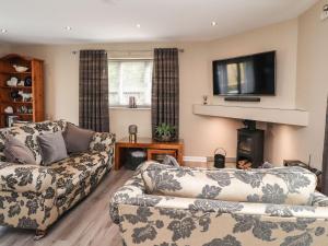 a living room with two couches and a flat screen tv at Kilmory Lodge in Poulton le Fylde