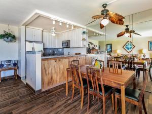 cocina y comedor con mesa de madera y sillas en Maui Sunset A-322, 3 Bedrooms, Ocean View, Pool, Tennis, Sleeps 8, en Kihei