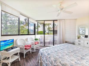 1 dormitorio con 1 cama, sillas y TV en Maui Sunset A-322, 3 Bedrooms, Ocean View, Pool, Tennis, Sleeps 8, en Kihei