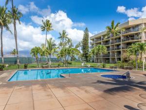 una piscina frente a un hotel con palmeras en Maui Sunset A-322, 3 Bedrooms, Ocean View, Pool, Tennis, Sleeps 8, en Kihei