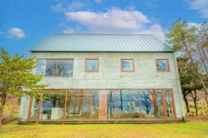 a house with glass windows and a metal roof at Lake Toya Villa SUSUKIAN in Sobetsu