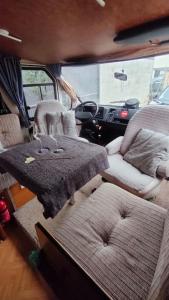einem Wohnmobil mit zwei Stühlen und einem Tisch darin in der Unterkunft Camping-car vintage in Venette