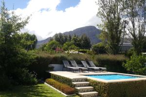 a swimming pool with lounge chairs next to a swimming pool at 5 Pierre Jourdan in Franschhoek