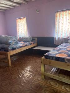 a room with two beds and two windows at Hotel Dancing Yak in Lete