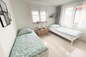 1 dormitorio con 2 camas y 2 ventanas en Große Wohnung Terrasse/Smart TV, en Korb