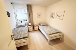 1 dormitorio con 2 camas y ventana en Große Wohnung Terrasse/Smart TV en Korb