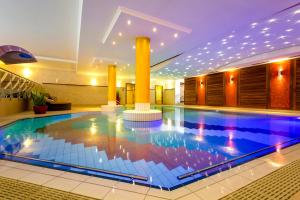 een groot zwembad in een hotel met verlichting aan het plafond bij Churfürstenhof Wellnesshotel in Bad Birnbach