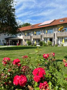 een gebouw met rode bloemen ervoor bij Churfürstenhof Wellnesshotel in Bad Birnbach
