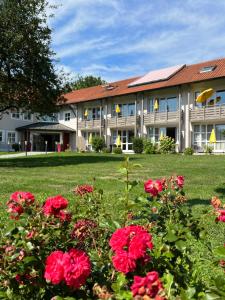 a building with red flowers in front of it at Churfürstenhof Wellnesshotel in Bad Birnbach