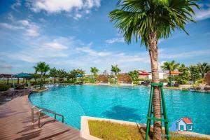 - une piscine avec un palmier et un toboggan dans l'établissement Almas Suites @ Puteri Harbour, à Nusajaya