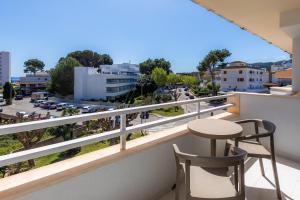 een balkon met een tafel en stoelen en uitzicht op de stad bij Apartament Massanet 2b in Canyamel