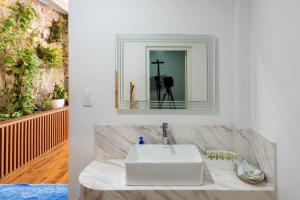 a bathroom with a white sink and a mirror at Coastal Village Phu Quoc in Phú Quốc