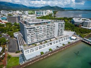 an aerial view of a large white building next to the water at 703 Harbour Lights Cairns Apartment with water views in Cairns