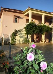 una casa con fiori rosa di fronte di Canditas Studios a Tsilivi