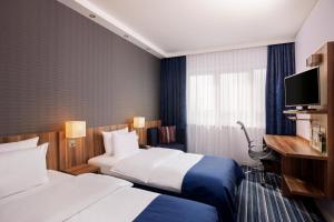 Habitación de hotel con 2 camas y TV en Holiday Inn Express Bremen Airport, an IHG Hotel en Bremen