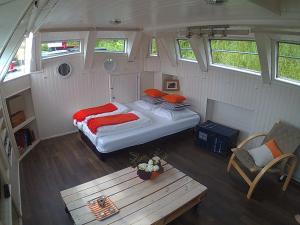 1 dormitorio con 1 cama y 1 mesa en un remolque en Péniche Nidd, en Dannemarie