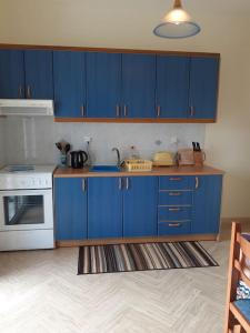 uma cozinha com armários azuis e um fogão branco em Relaxing rural retreat in mainland Greece em Ermioni