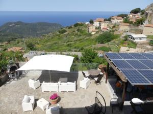 un solárium con sillas, una mesa y un conjunto solar en Giglio Castello - alloggi Mario & Marta, en Isola del Giglio