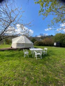 une tente avec une table et des chaises dans un champ dans l'établissement Loire Valley Llama Farm Stay, à Lavernat