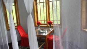 una mesa con 2 sillas rojas y una ventana en Rakaposhi Amin Hotel & Restaurant Pissan Hunza Nagar Gilgit Baltistan en Gilgit