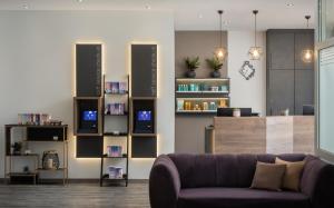 a living room with a purple couch and book shelves at AWA Hotel in Munich