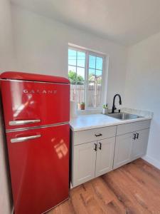 een rode koelkast in een keuken met een wastafel bij 5B3B Single house with gated front and back yard in San Jose