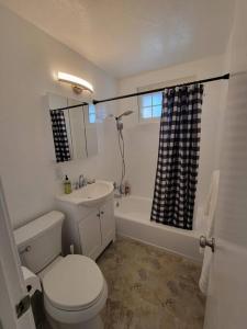een witte badkamer met een toilet en een wastafel bij 5B3B Single house with gated front and back yard in San Jose