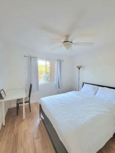 een slaapkamer met een bed, een plafondventilator en een bureau bij 5B3B Single house with gated front and back yard in San Jose