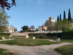 a park with benches in front of a building at B&B Gardasee in Castelnuovo del Garda