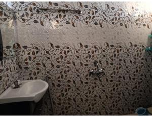 La salle de bains est pourvue d'un lavabo et d'un rideau de douche. dans l'établissement Hotel Sunnyside Palace, Almora, à Almora
