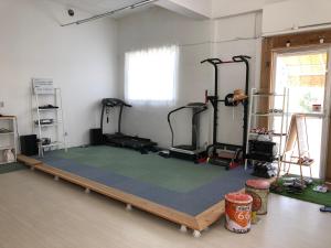 a gym with several tread machines on a wooden frame at POSSE宮古島and宮古島ウエストレンタカー Wi-Fi完備 in Miyako Island