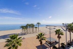 Una vista de una playa con palmeras y el océano. en HAPPYVILA Apartments, en Villajoyosa