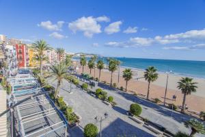 vistas a la playa, a los edificios y a las palmeras en HAPPYVILA Apartments, en Villajoyosa