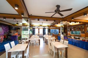 a restaurant with white tables and white chairs at S.B.Living Place in Phuket